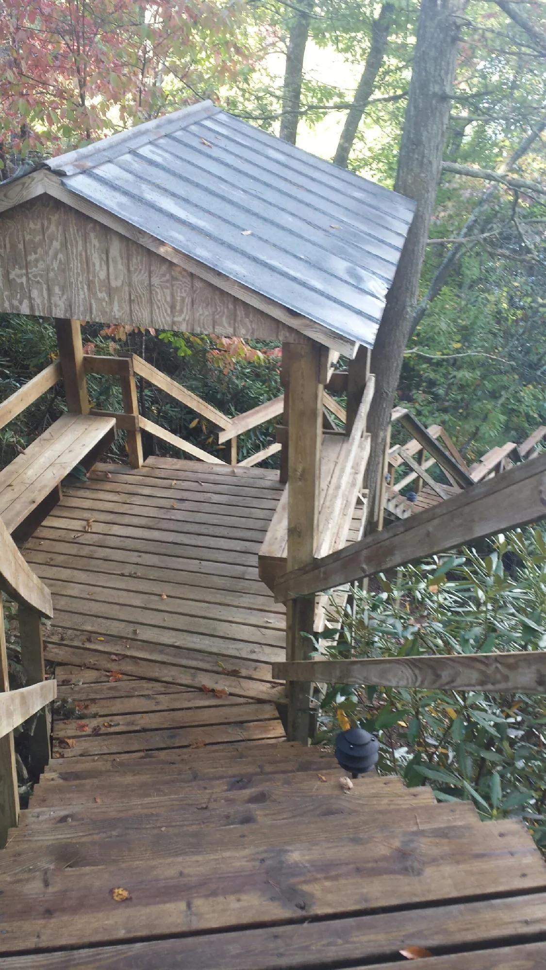 Metal roofed shelter over wooden steps on a wooded walkway — Skylight Repair & Installation work by our crew in Whately