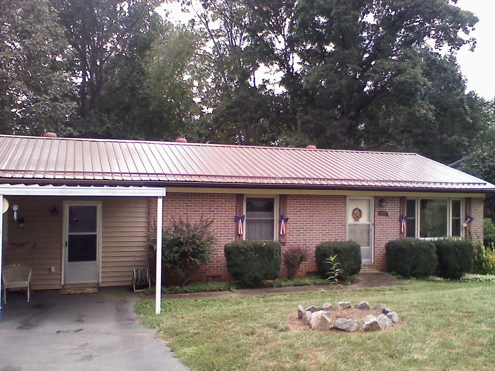 Bronze metal roof and carport on a brick ranch home — Roof Repair work by our crew in Whately